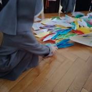 Children putting together paper boats