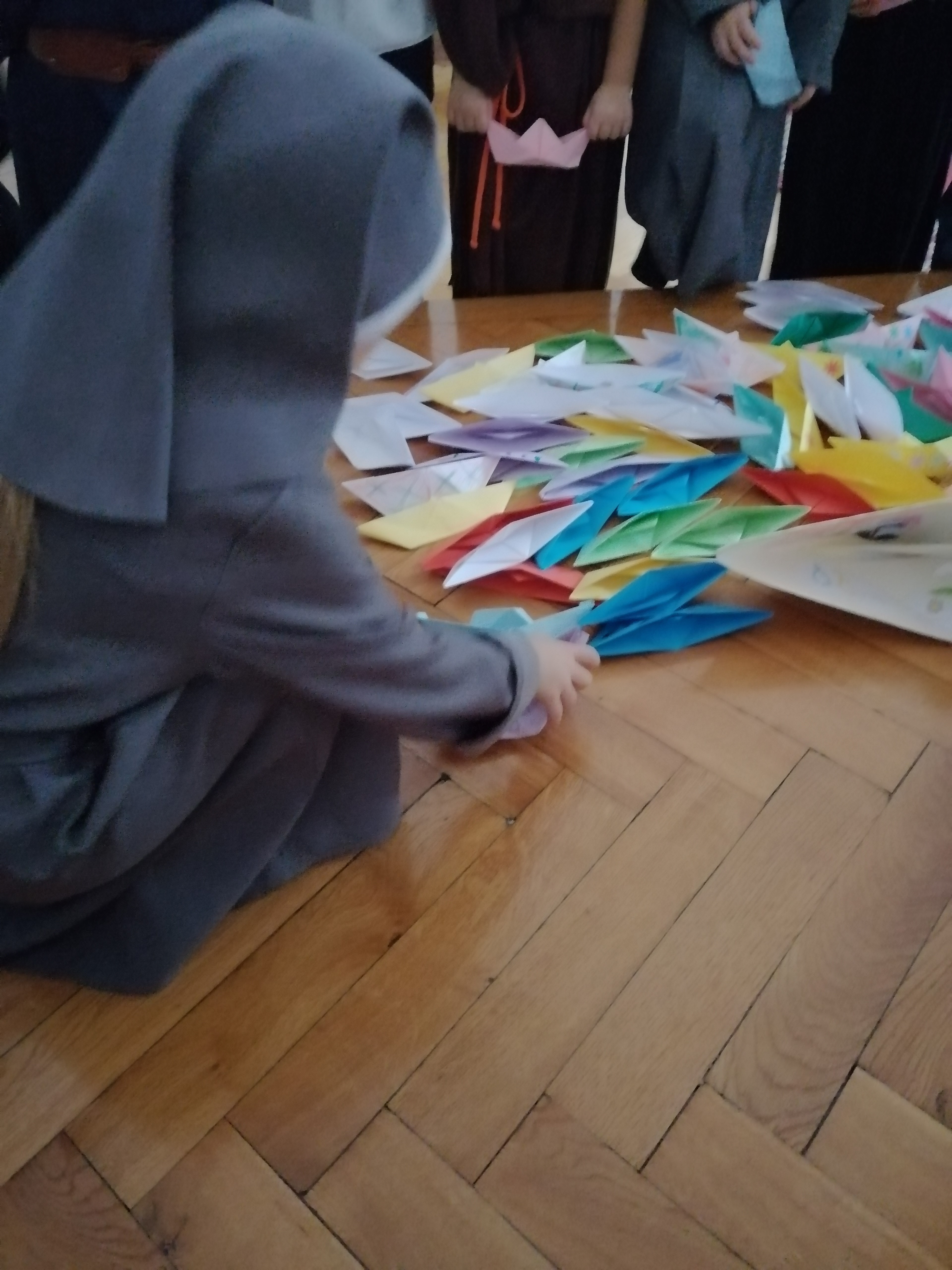 Children putting together paper boats